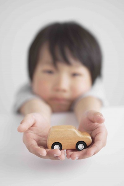 木製の車のおもちゃを持つ男の子