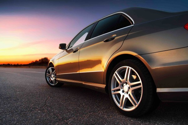 Rear-side view of a luxury car on sunset